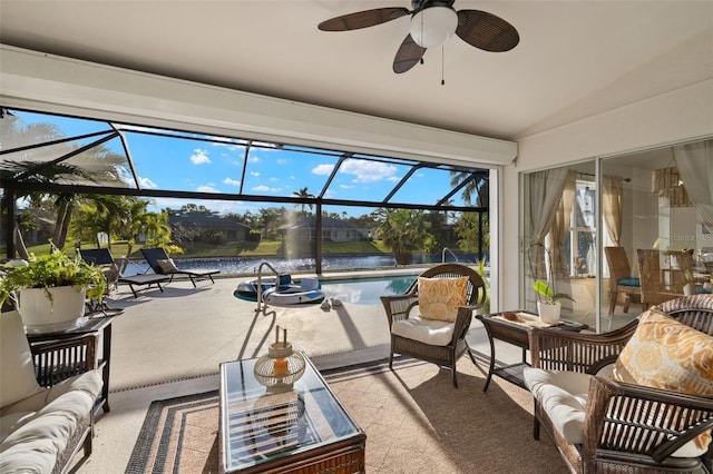 sunroom with ceiling fan, a water view, and vaulted ceiling