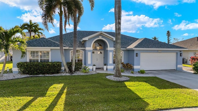 ranch-style house featuring a garage and a front lawn