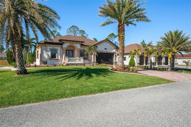 mediterranean / spanish-style home with a front yard and a garage