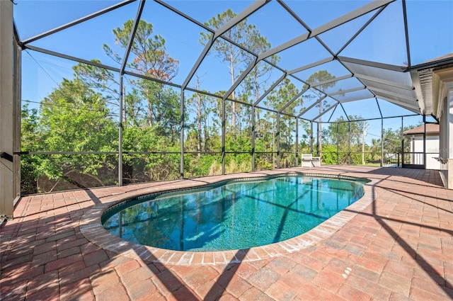 view of pool featuring glass enclosure and a patio