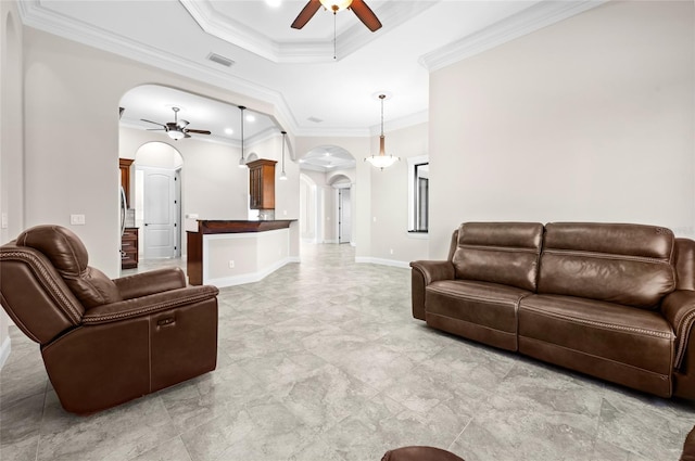 living room with a raised ceiling, ceiling fan, and ornamental molding