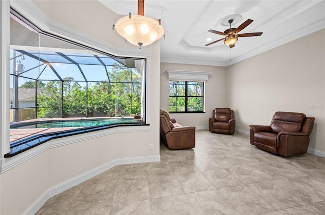 sitting room with a raised ceiling, ceiling fan, a swimming pool, and ornamental molding