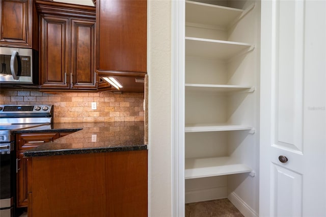 kitchen featuring decorative backsplash, dark stone counters, and appliances with stainless steel finishes