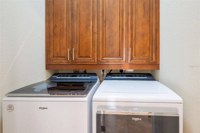 clothes washing area with cabinets and independent washer and dryer