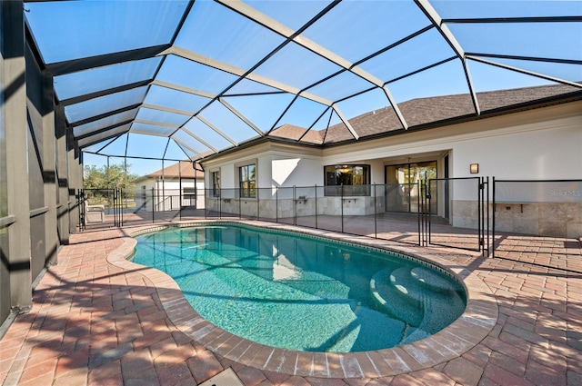 view of swimming pool with glass enclosure and a patio area