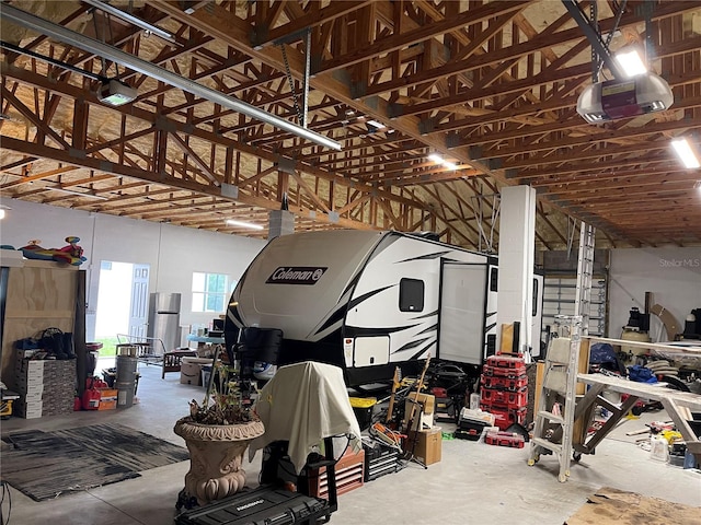 garage featuring stainless steel fridge and a garage door opener