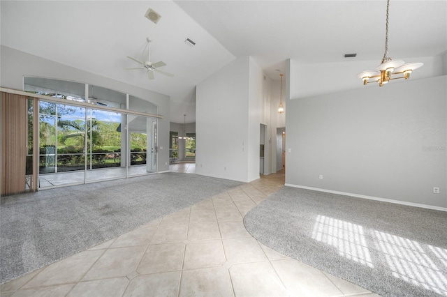 unfurnished living room with high vaulted ceiling, tile patterned flooring, ceiling fan with notable chandelier, carpet flooring, and visible vents