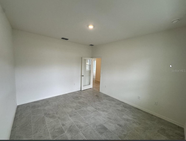 spare room with recessed lighting, visible vents, and baseboards