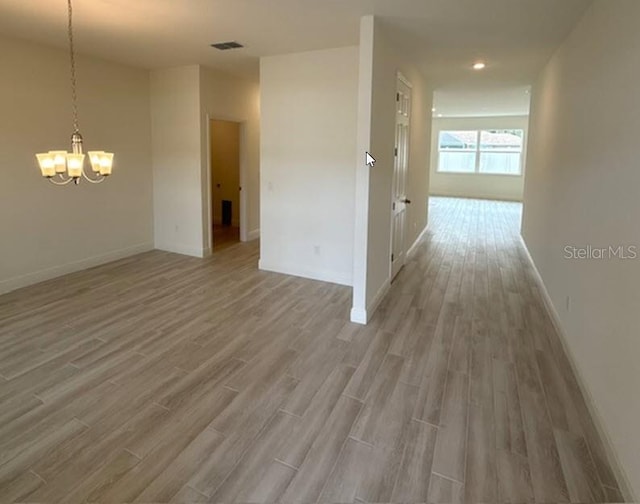 hall with a chandelier and wood-type flooring