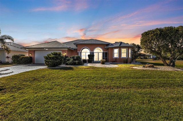 view of front of house featuring a garage and a lawn