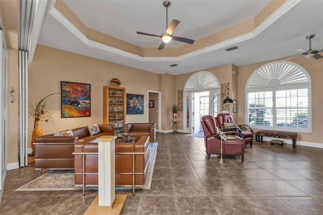 living room with a tray ceiling, ceiling fan, tile patterned flooring, and ornamental molding