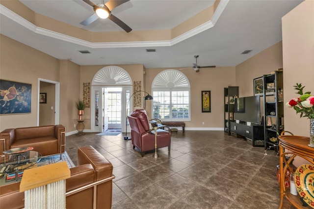 living room featuring a raised ceiling, ceiling fan, and crown molding