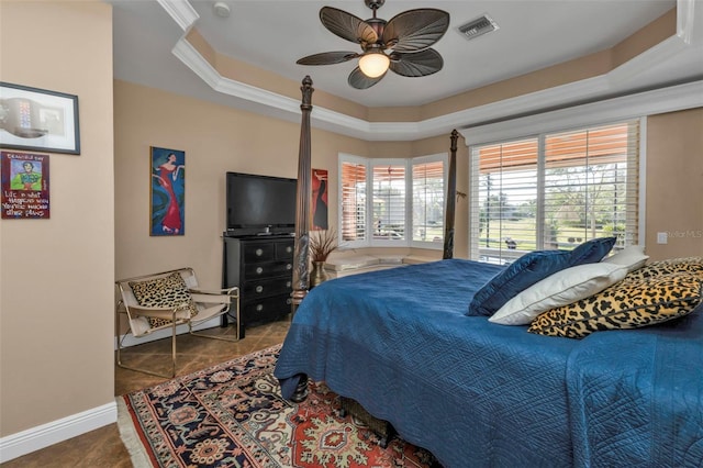 bedroom featuring a tray ceiling, tile patterned floors, ceiling fan, and crown molding