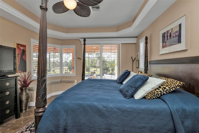 bedroom featuring ceiling fan, access to exterior, and a tray ceiling