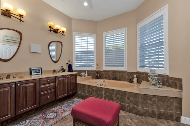 bathroom featuring tile patterned floors, vanity, and tiled tub