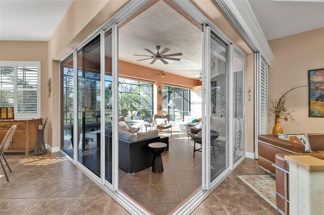 doorway to outside with ceiling fan, tile patterned flooring, and a textured ceiling