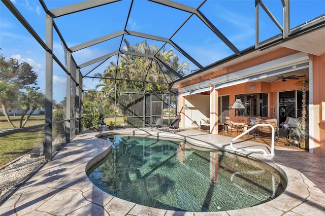 view of pool with glass enclosure, ceiling fan, and a patio