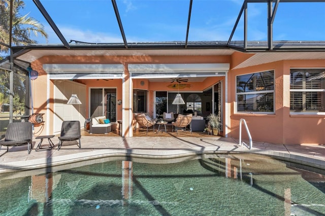 view of pool with glass enclosure, ceiling fan, and a patio