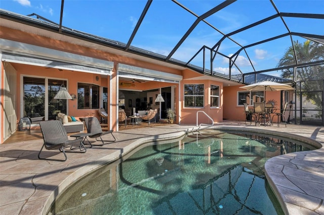 view of swimming pool with a patio area, ceiling fan, glass enclosure, and an outdoor living space