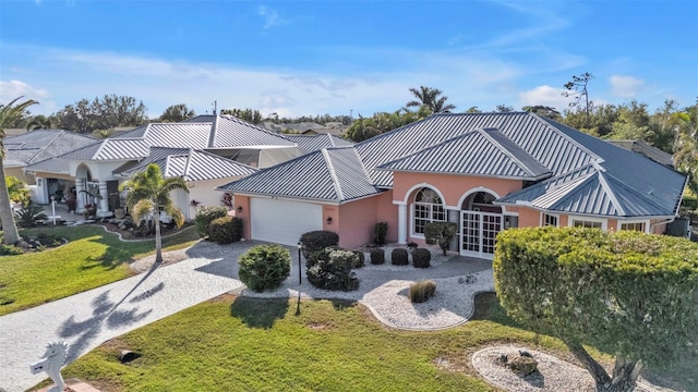 view of front of house with french doors, a garage, and a front lawn