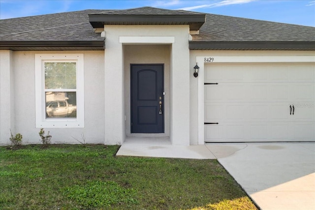 property entrance featuring a yard and a garage