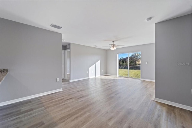 unfurnished living room featuring hardwood / wood-style flooring and ceiling fan