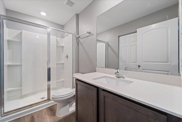 bathroom with walk in shower, toilet, vanity, and hardwood / wood-style flooring