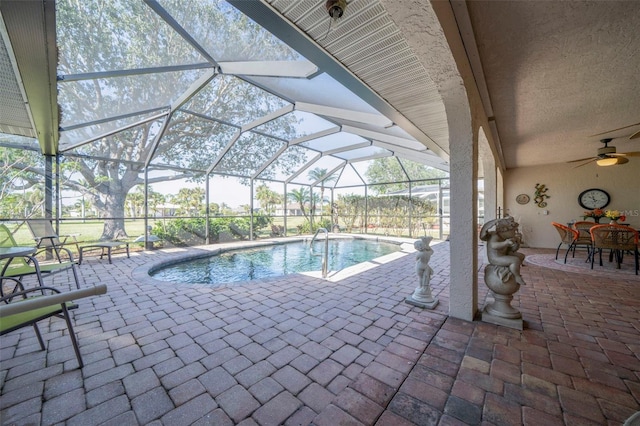 view of swimming pool featuring glass enclosure and a patio area