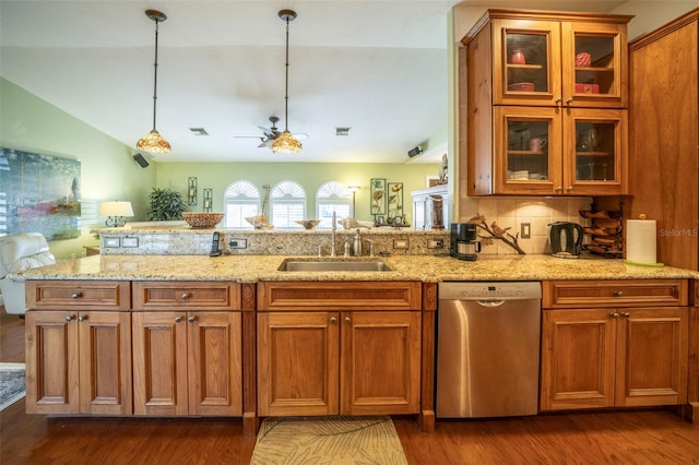 kitchen with pendant lighting, lofted ceiling, sink, stainless steel dishwasher, and tasteful backsplash