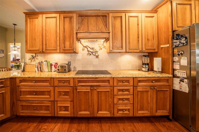 kitchen featuring stainless steel fridge, dark hardwood / wood-style flooring, tasteful backsplash, black electric stovetop, and decorative light fixtures