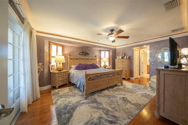 bedroom with ceiling fan, ornamental molding, and hardwood / wood-style flooring