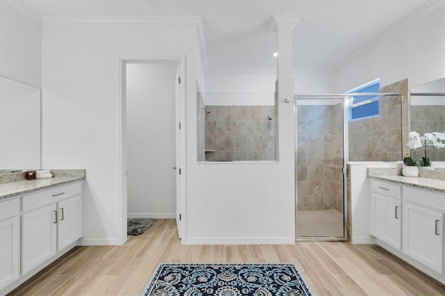 bathroom with crown molding, a shower with door, and vanity