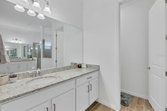 bathroom with vanity, ornamental molding, and walk in shower