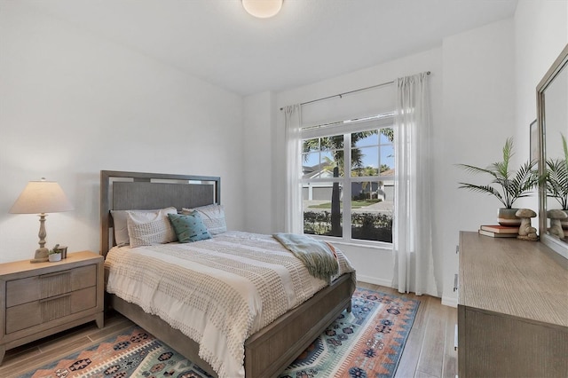 bedroom with light hardwood / wood-style floors and multiple windows