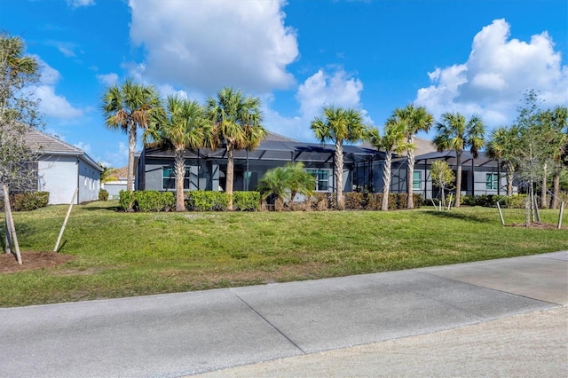 view of front of house with glass enclosure and a front yard