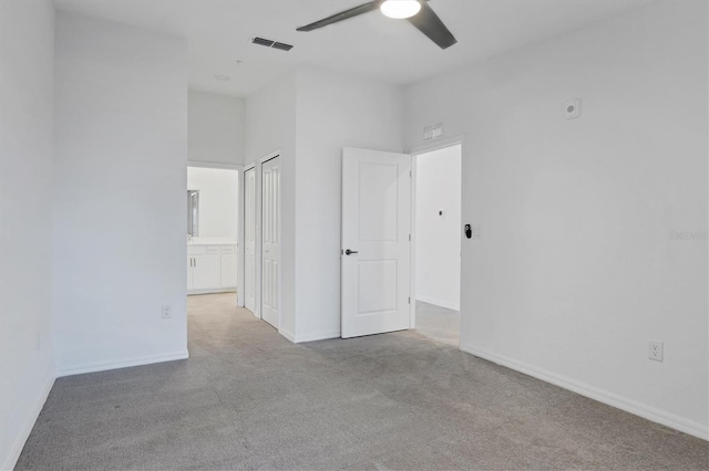 12470 Wellen Golf St Unit 203, Venice, FL 34293 - unfurnished bedroom featuring connected bathroom, light colored carpet, ceiling fan, and a closet