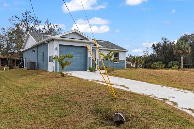 view of front facade featuring a front yard, a garage, and central AC unit