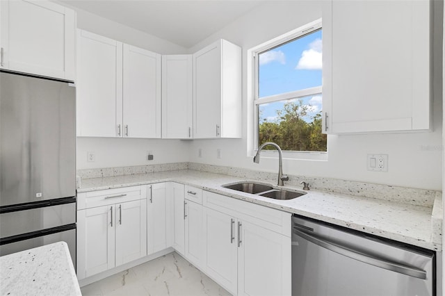 kitchen featuring light stone counters, sink, white cabinets, and appliances with stainless steel finishes