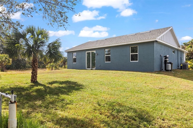 back of house featuring a lawn and central AC unit