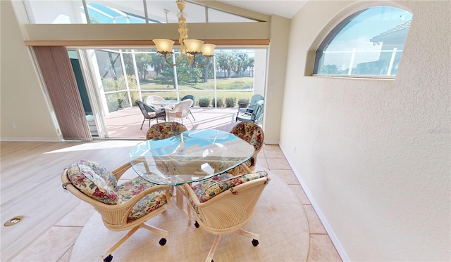 dining area with light tile patterned flooring, vaulted ceiling, and an inviting chandelier