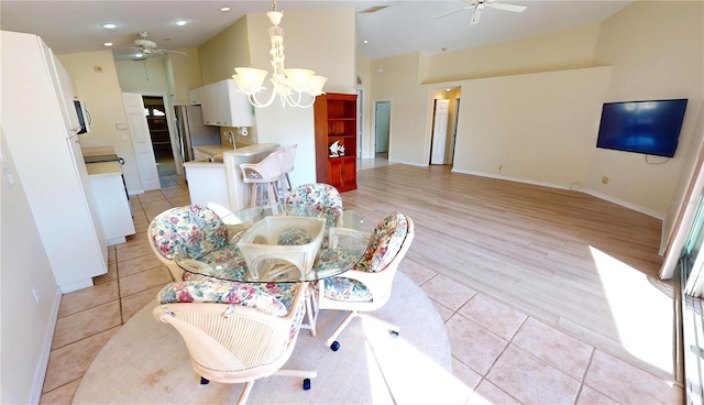 dining space featuring ceiling fan with notable chandelier and light hardwood / wood-style floors