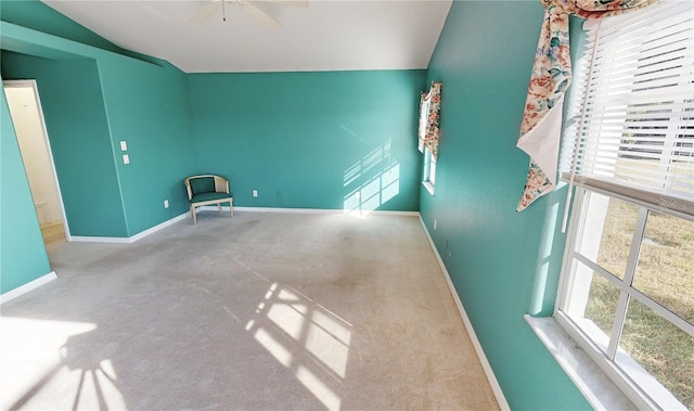 spare room featuring ceiling fan, light colored carpet, and lofted ceiling