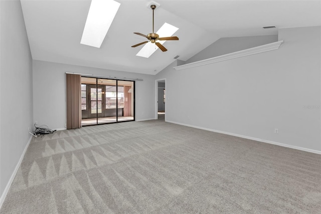 carpeted spare room featuring ceiling fan and vaulted ceiling with skylight