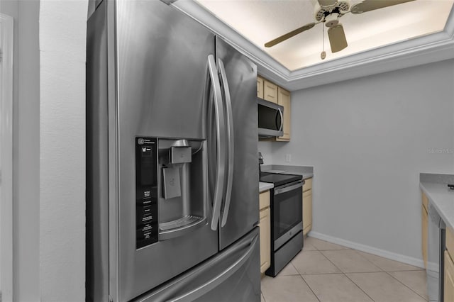 kitchen featuring a raised ceiling, ceiling fan, light tile patterned floors, and stainless steel appliances