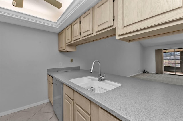 kitchen with light tile patterned flooring, light brown cabinetry, white dishwasher, and sink