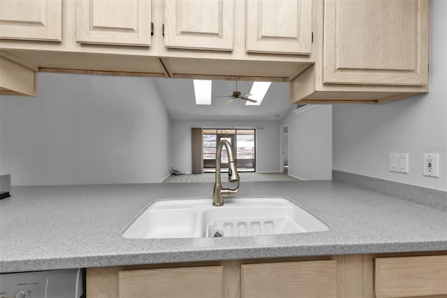 kitchen featuring dishwasher, sink, ceiling fan, light stone countertops, and light brown cabinetry