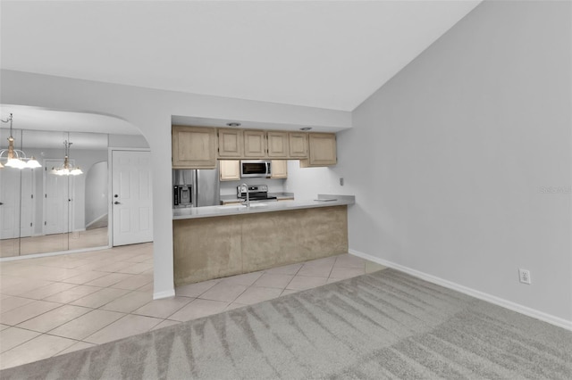 kitchen with appliances with stainless steel finishes, light tile patterned floors, hanging light fixtures, and light brown cabinetry