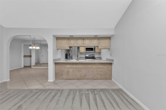 kitchen with light brown cabinets, a notable chandelier, pendant lighting, light tile patterned floors, and appliances with stainless steel finishes