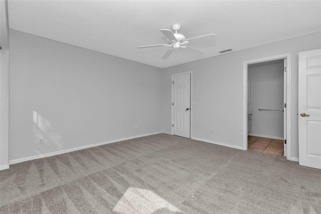 unfurnished bedroom with light carpet, connected bathroom, and ceiling fan