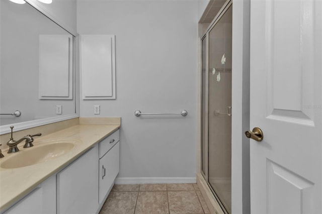 bathroom with tile patterned floors, vanity, and a shower with door